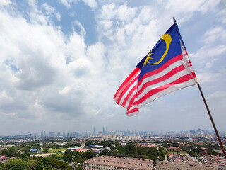 KUALA LUMPUR, MALAYSIA -JULY 1, 2022: The Malaysian flag aka Jalur Gemilang is flown at a high place and against the backdrop of the Kuala Lumpur skyline
