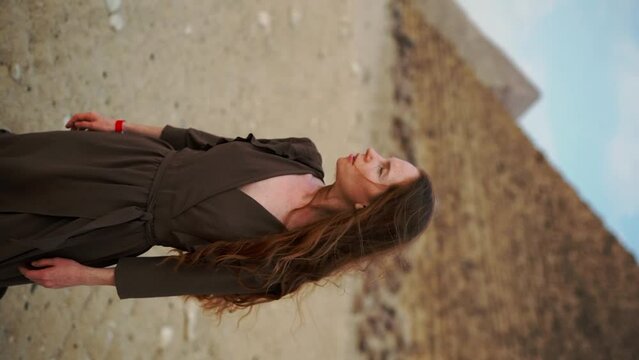 Vertical Instagram video. Young redhead girl in brown dress walking near piramids in Egypt, Cairo - Giza. Copy space