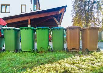 Obraz premium Garbage cans in different colors for waste management, trash recycling bins on the street