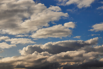 blue sky with shadowed white clouds, gently moved by the winds.