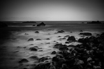 Obraz premium Rocky coast with blurred waves 