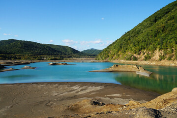 toxic blue lake in green mountain valley