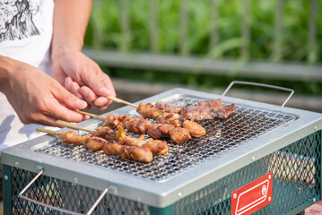 BBQで焼き鳥を焼いている男性の手元