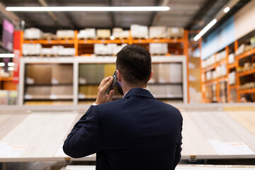 supplier of building materials in the store talking on the phone Looking at the shop window