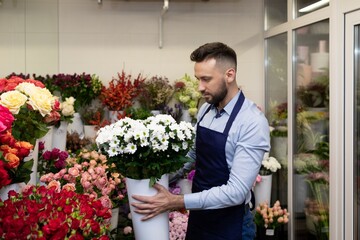 florist with a vase of plants in his hands inside the refrigerator