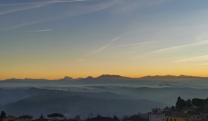 Un mare di nebbia e nuvole al tramonto riempie le valli ai piedii dei monti appennini