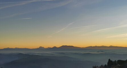 Un mare di nebbia e nuvole al tramonto riempie le valli ai piedii dei monti appennini