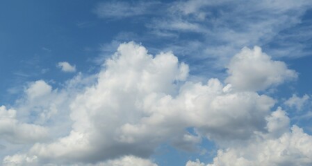 Naklejka na ściany i meble Beautiful fluffy clouds in blue sky