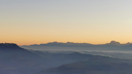 Un mare di nebbia e nuvole al tramonto riempie le valli ai piedii dei monti appennini