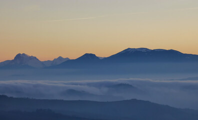 Naklejka na ściany i meble Un mare di nebbia e nuvole al tramonto riempie le valli ai piedii dei monti appennini