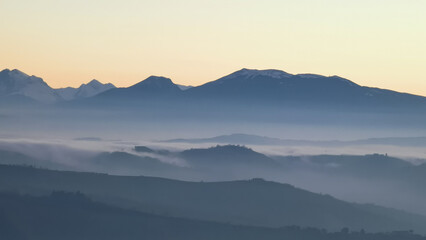 Obraz na płótnie Canvas Un mare di nebbia e nuvole al tramonto riempie le valli ai piedii dei monti appennini
