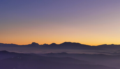 Tramonto viola e arancio sui monti le valli e le colline