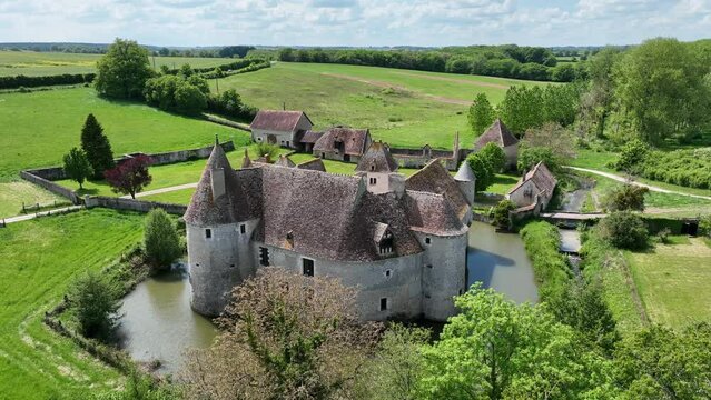 Aerial view of Buranlure water castle in the middle of a lush green meadow in the Loire valley