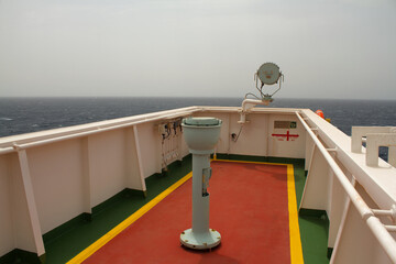 View of the bridge wing with compass and search light on board a ship at sea