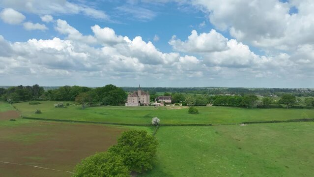 Aerial view of Chateau de Beauvoir restored medieval French castle with bridge, towers, manicured lawn and garden