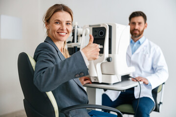 Woman happy with result after checking eyesight in ophthalmology clinic 