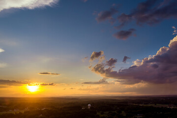 Gorgeous panorama view in through the clouds in the sky, a dramatic orange light sunset emerges