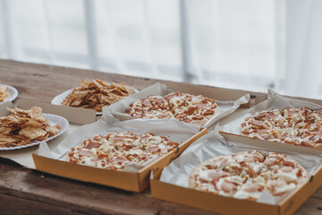 Many pizzas are placed on the table at the company, corporate office parties, startups, Italian food, pizza popular food that is easy to find and popular at parties. Party food ideas.