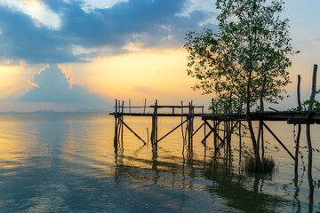 Sunset on the lake with wooden bridge.