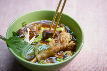 Rice stick noodles mixed with braised chicken in a ceramic bowl