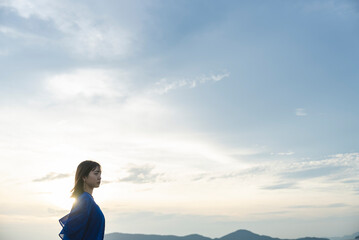 夕暮れの海にいる女性