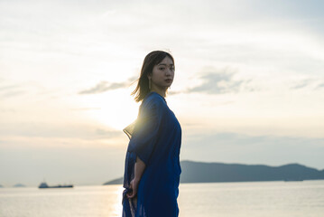 夕暮れの海にいる女性