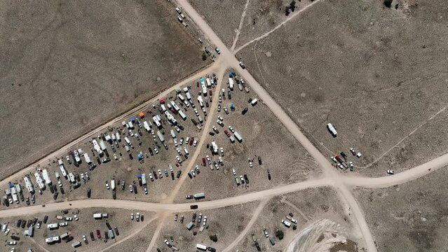 Aerial Desert motorcycle race camps pit row circle climb high. Extreme desert motocross motorcycle race in dry rugged Utah terrain. Championship competition and fun. Sport recreation family fun, camp.
