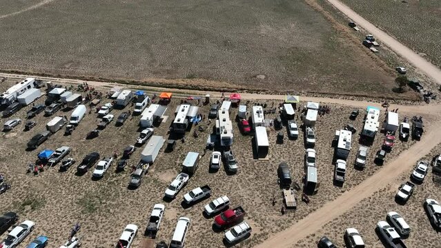 Aerial Desert motorcycle race camps pit row circle fast. Extreme desert motocross motorcycle race in rural desert community. Championship competition. Sport recreation family fun entertainment.