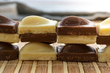 white chocolate and milk chocolate pieces sliced or cutted on bamboo table and stacked over each other