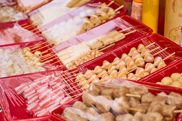 Fresh sausage and hot dogs with different  shape on a red pbox and covered with plastic wrap