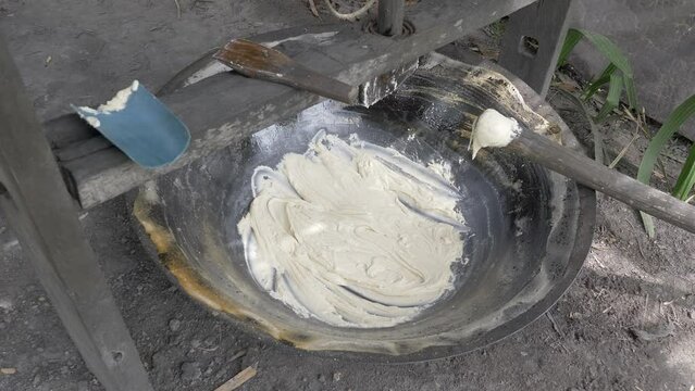 close up of the palm juice becomes thick , ready to be stirred slowly until the paste crystallizes