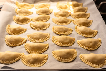 Pierogi, pirohy, filled dumplings on a baking paper, uncooked dough, Slovak dish, preparing food,...