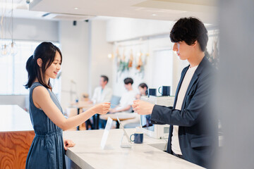 Obraz premium レジでクレジットカード決済をする若い女性