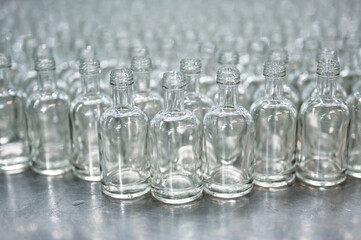 Lines of empty glass bottles for vodka drink in workshop