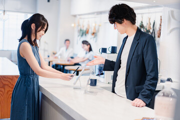 スマホ決済をする若い女性