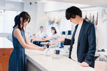 Fototapeta premium スマホ決済をする若い女性