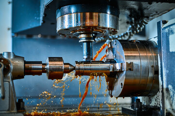 Lathe machine tool operates with metal part in workshop
