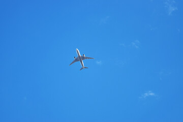 ジャンボジェット機が青い空を飛ぶ。飛行機は便利な交通手段。