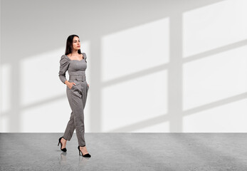 Fototapeta na wymiar Businesswoman hands in pocket, walking with pensive look on white background. Copy space