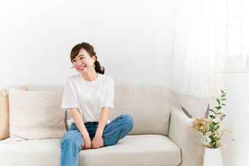 Obraz premium 家のソファに座る笑顔の日本人女性（話す） 
