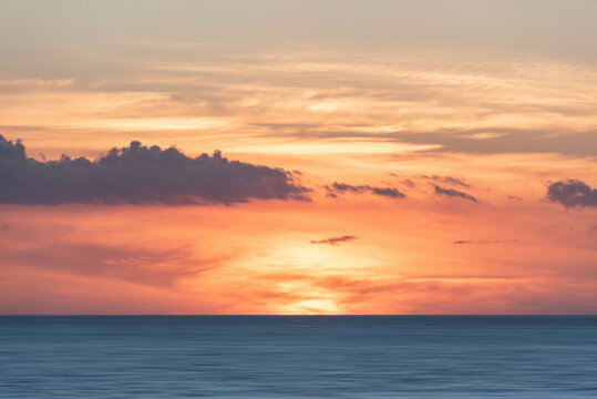 Beautiful colorful dramatic deep vibrant sunset over ocean landscape image