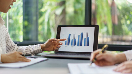 Coworker business concept, Two businesswoman pointing on chart financial to discussing together