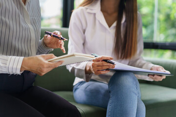 Coworker business concept, Two businesswoman discussing about chart financial and taking notes data