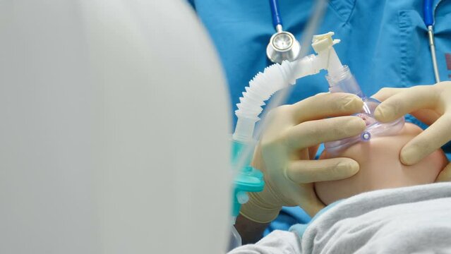 General anesthesia in hospital. Surgical intervention. Anesthesiologist at work. Breathing tube and mask on kid face. Artificial ventilation of lungs. Healthcare and life saving concept. Preparation