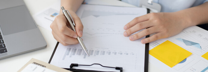 Asian women are analyzing graphs, market data and assessing investment risks, Working at home during the outbreak of the virus or social spacing, Refraining from spreading germs.