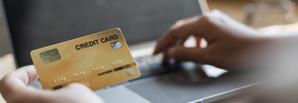 Woman's finger presses a keyboard and holds a credit card to register for payment or online transactions, Financial transactions and Internet security, Shopping online and banking online concept.