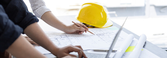 Meeting of engineers and architects in building planning, Consulting and brainstorming experts in architectural planning using blueprints, tape measure, rulers, laptop in designing buildings.