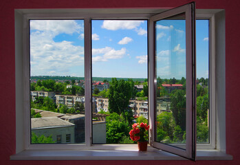 View of the city through the window frame from a tall building.