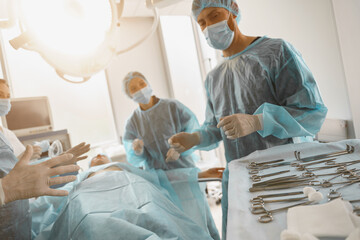 Concentrated professional surgical team working with a patient in an operation room