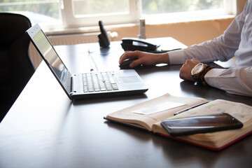 Businessman sitting in modern office and working on his laptop
